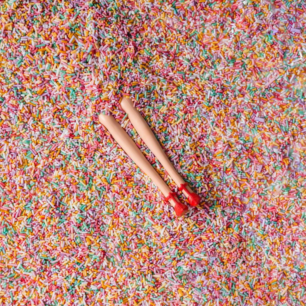 Doll legs buried in colorful sprinkles