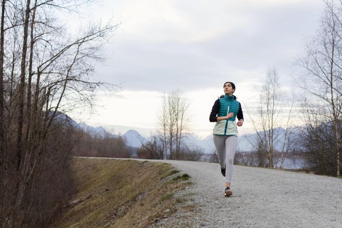 Young woman jogging on a lake path