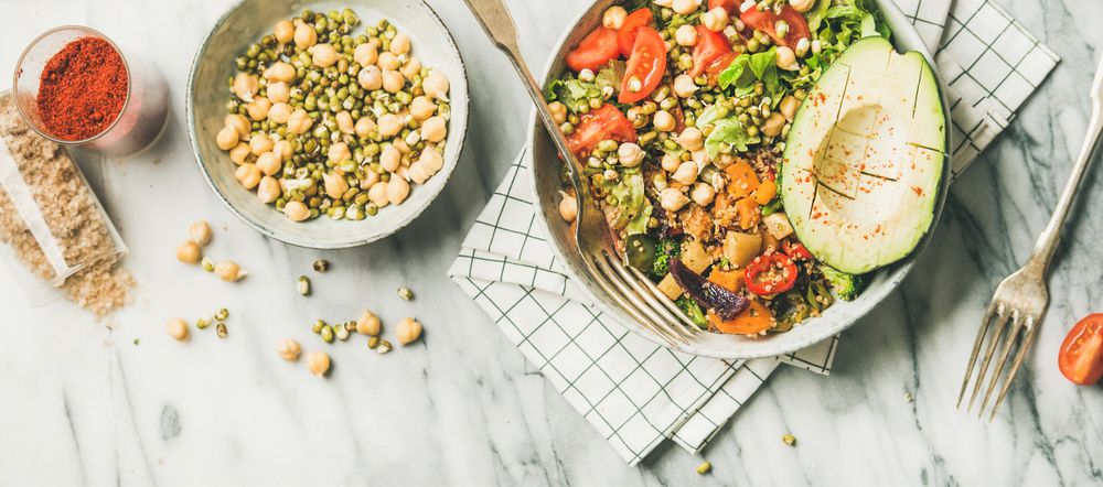 Healthy vegan lunch bowl with avocado, sprouted grains, vegetables, paprika, wide composition
