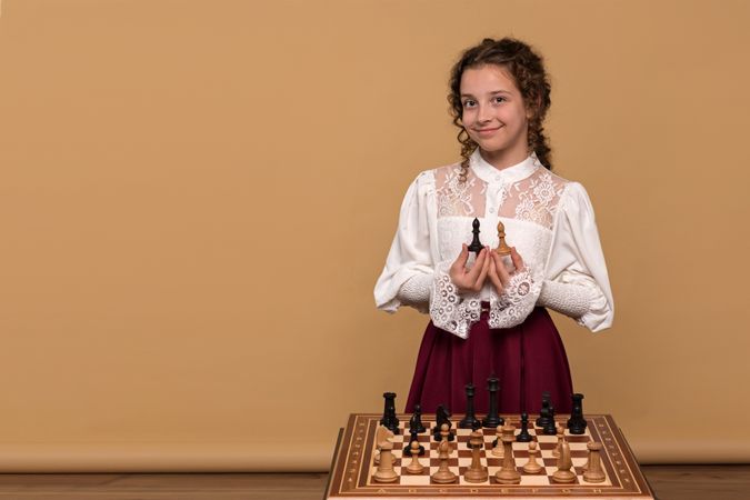 Young girl holding chess pieces