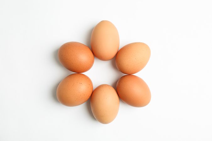 Flat lay composition with chicken eggs on light background, space for text