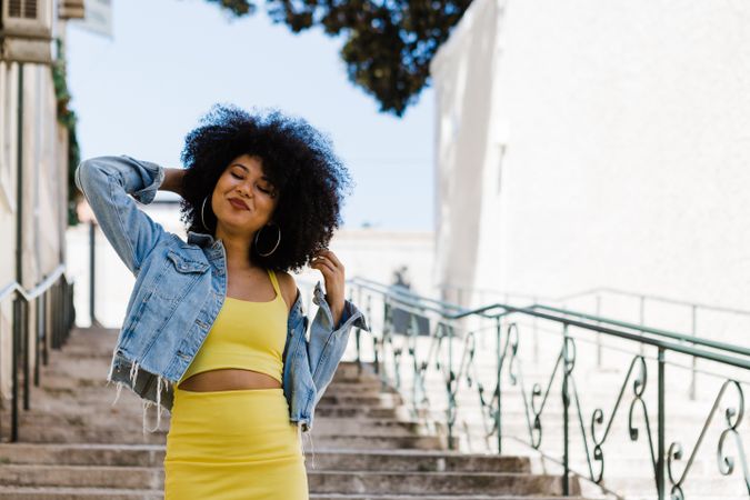 Stylish female standing on stairs with railing outdoors
