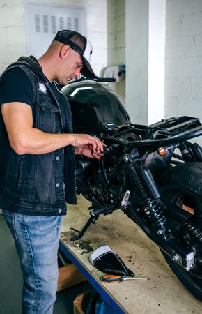 Motorcycle mechanic changing a fuse
