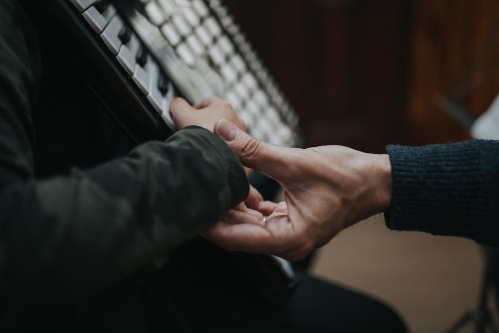 Adult educating student how to play chords on accordion