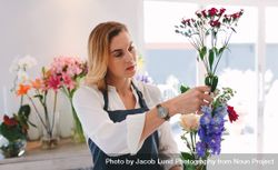 Female working at flower shop arranging flowers 0J8XZ4