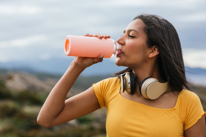 Woman drinking water from reusable bottle