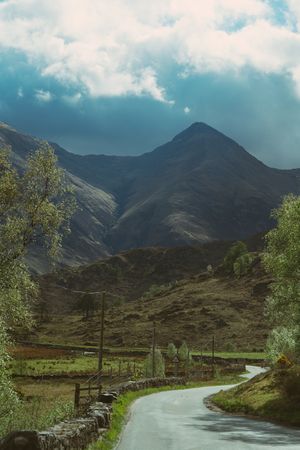 Road and mountain peak against blue sky