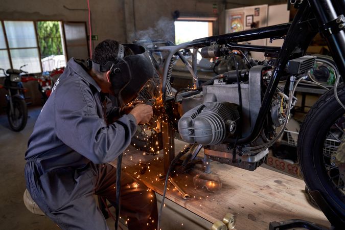 Anonymous technician working with welding machine while repairin