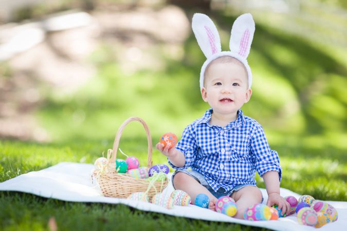 Boy In Rabbit Ears Playing with Easter Eggs