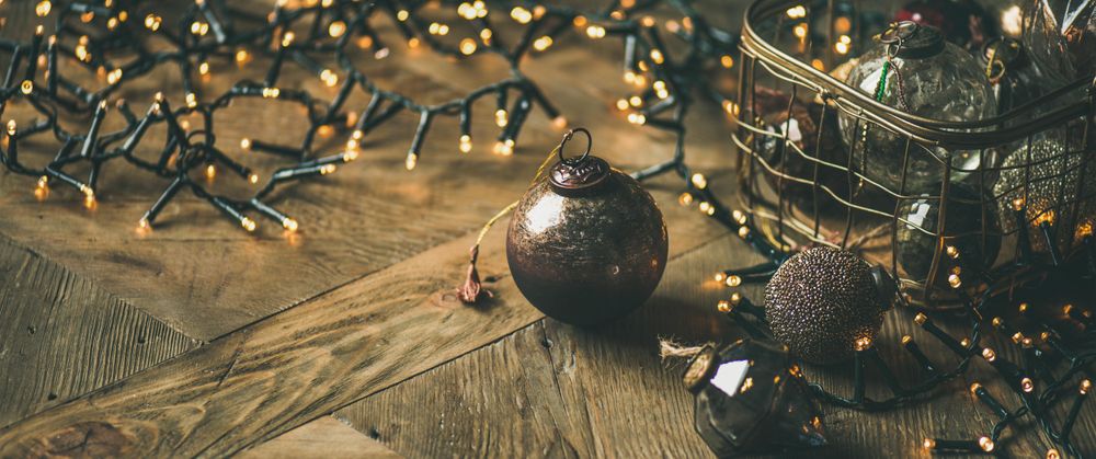 Christmas tree decorations in wire box, on wooden counter, copy space