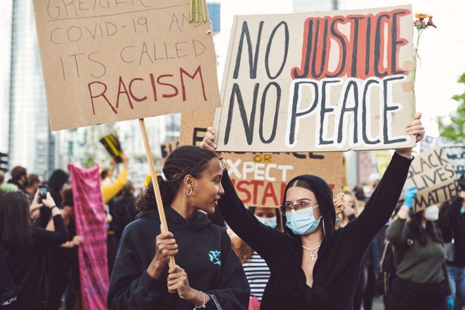 London, England, United Kingdom - June 6th, 2020: Two women holding protest signs in crowd