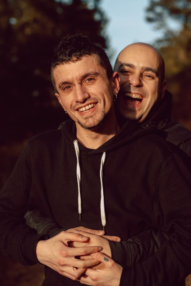 Smiling men hugging on path in park