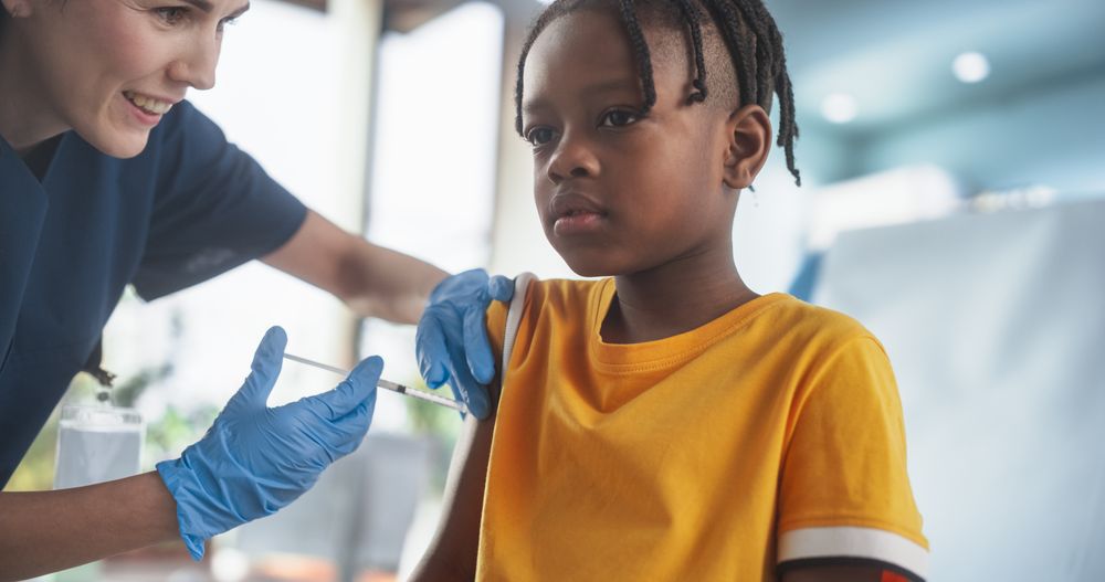 Female Nurse Performing Injection to Worried Kid
