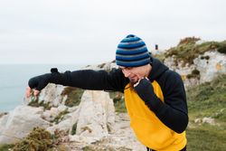 Kickboxer training on cliff near sea