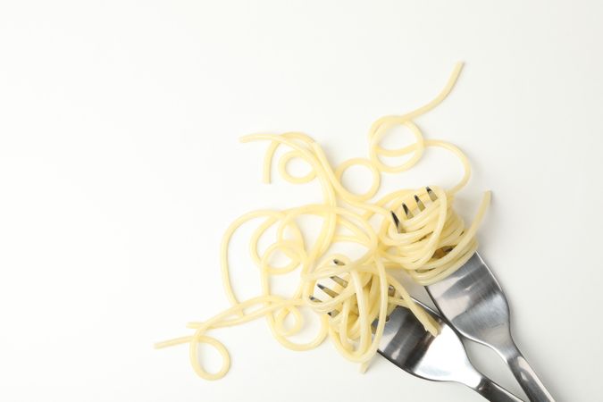 Forks with tasty pasta isolated on plain background