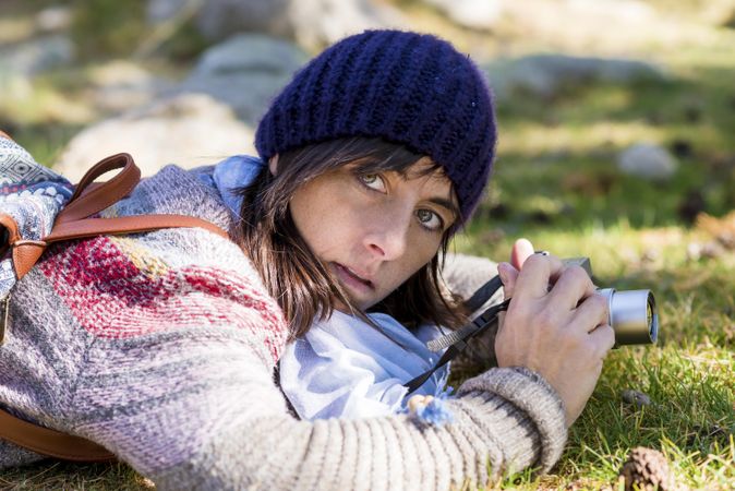 Female lying on the grass taking a picture