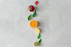 Fruits and herbs on bright marble table background