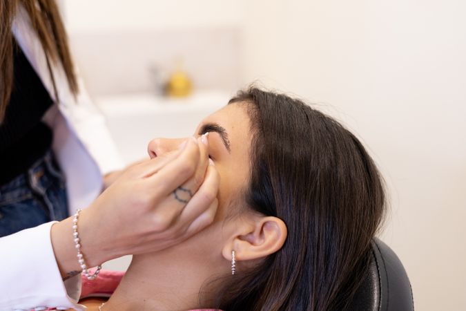 Beautician making eyebrow design and shading procedures