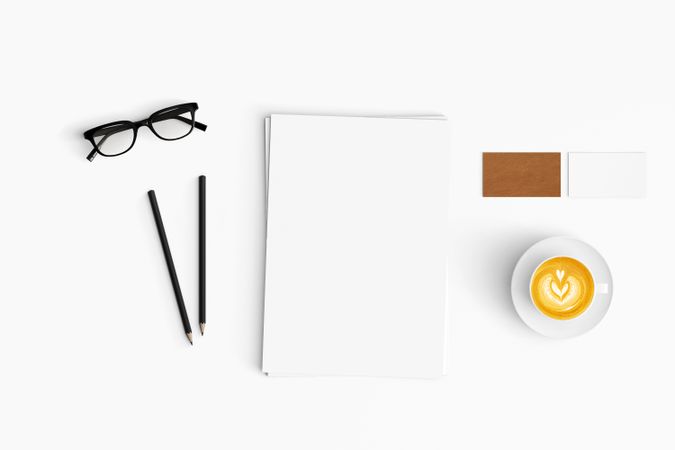 Modern workspace with coffee cup, paper and pencils copy space