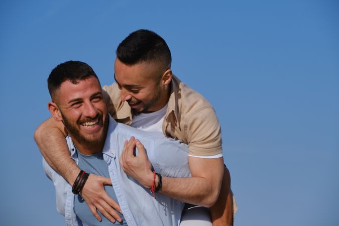 Happy gay couple playing piggyback