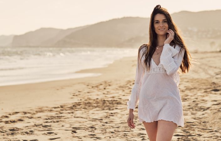 Young woman at the beach at sunset