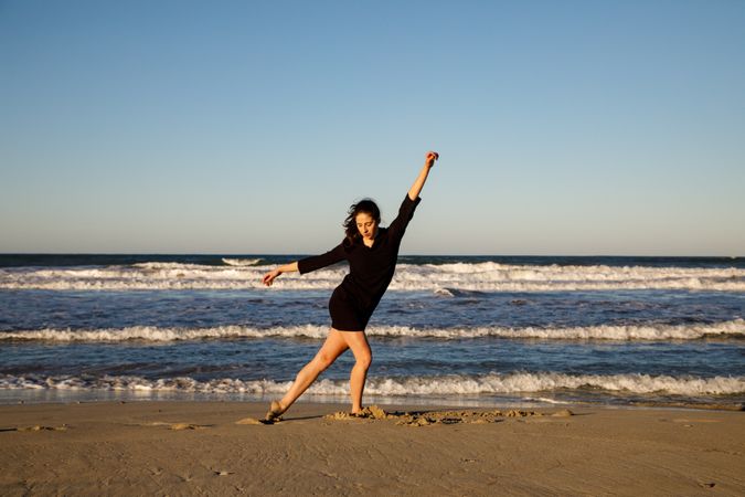 Woman with dancing near water on shore