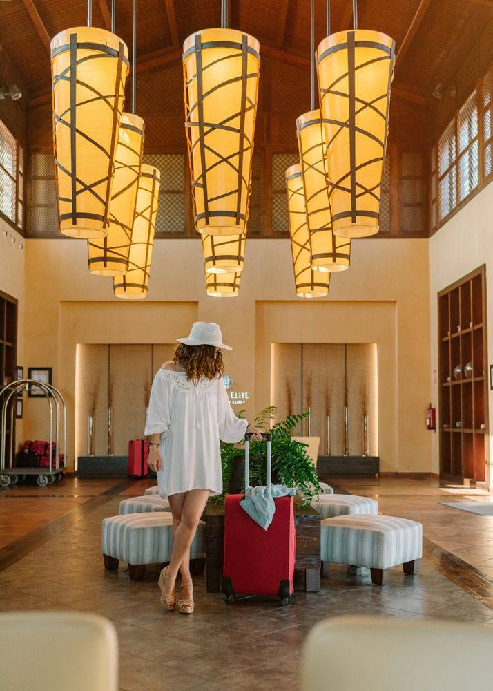 Woman with suitcase waiting at hotel lobby