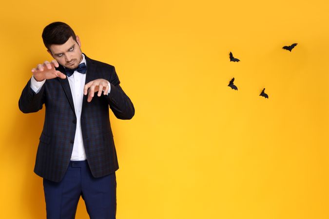 Concept of Halloween, young man on yellow background