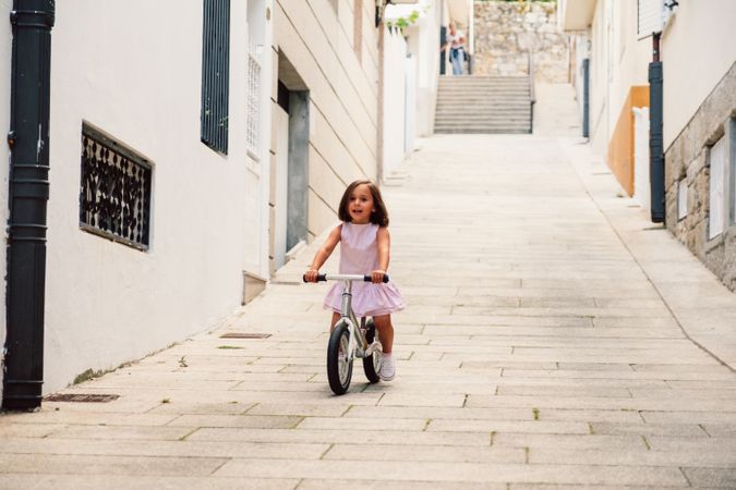 Girl riding on bicycle in narrow street