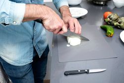 Man chopping onion on board