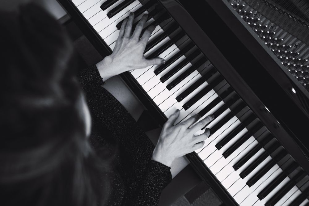 Top view of cropped hands playing the piano