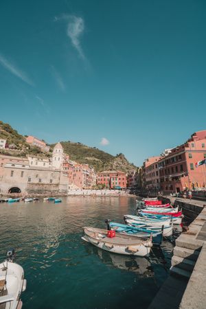 Boats on calm body of water beside buildings