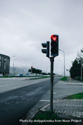 Red traffic light in heart shape against overcast sky, vertical 5nD9Zb