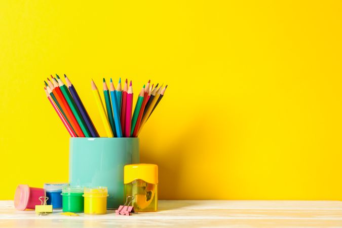 School supplies on wooden table against color background, space for text