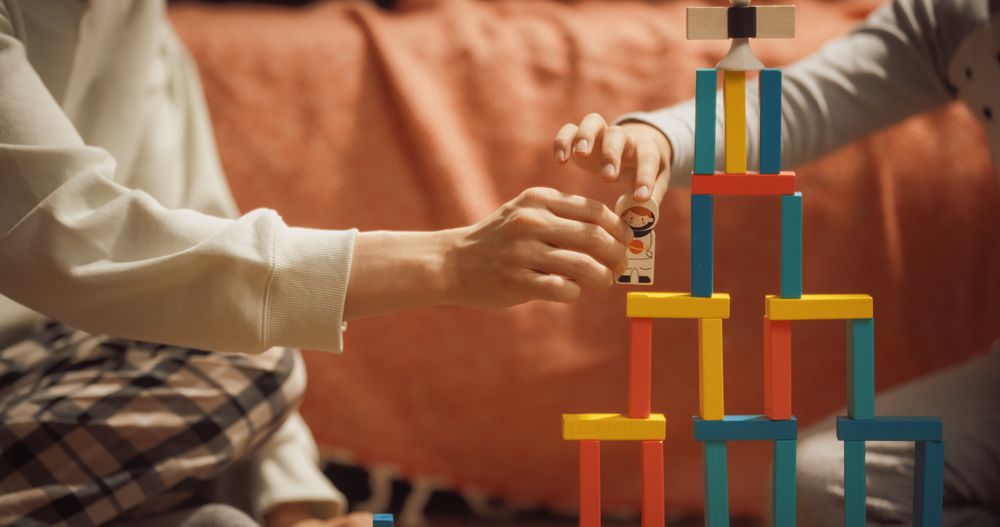 Close Up Shot Of an Anonymous Kid Playing with Wooden Construction Blocks with His Parent.