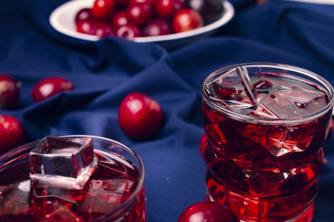 Red beverage near fresh fruits on cloth