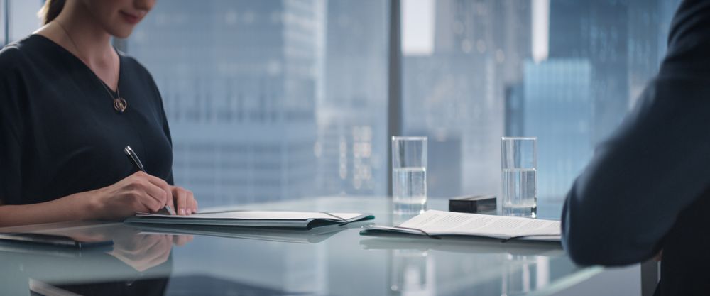 Close Up Of Female and Male Business Partners Sign Successful Deal and Shake Hands in Skyscraper Office.