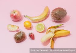 Plastic wrapped fruit on pink background 0VgVG5