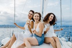 Cheerful friend with wine having fun on yacht