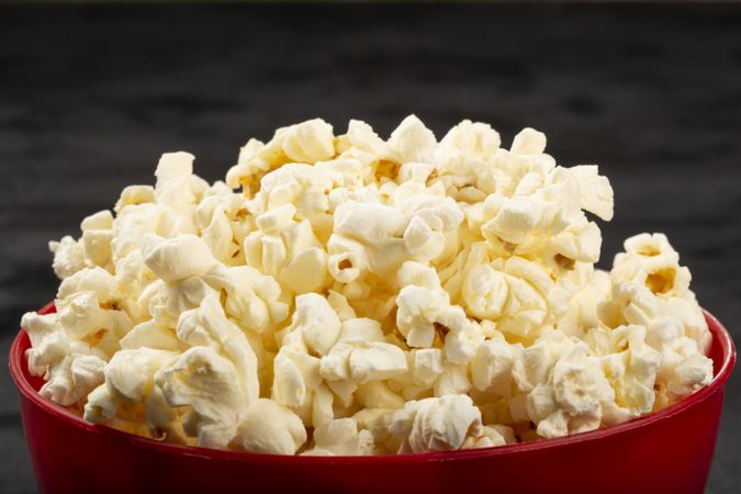 Bowl with salted popcorn sore the table.