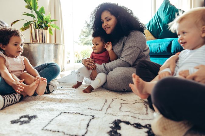 Women with their babies sitting on floor of home