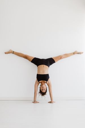 Sportive woman performing yoga pose in room