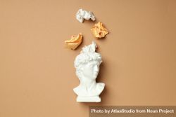 Marble bust with crumpled paper coming out of brain on brown background 42ZkK4