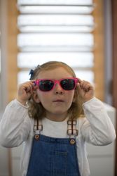 Young girl trying on glasses