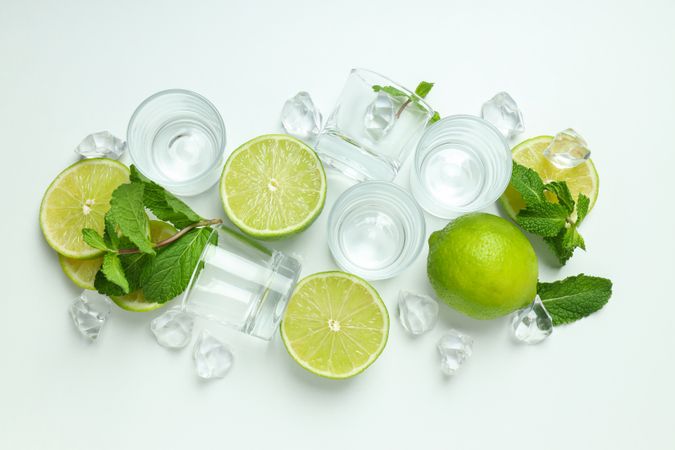 Glasses for shots and ingredients for cocktails on blank background