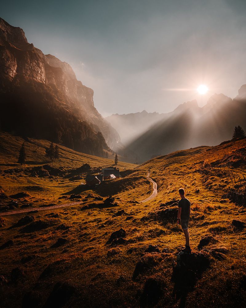 Man standing on hill beside mountains