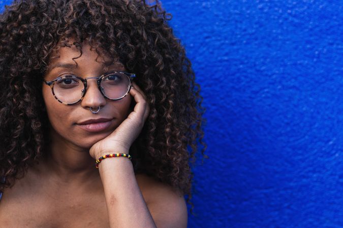 Woman against bright blue wall