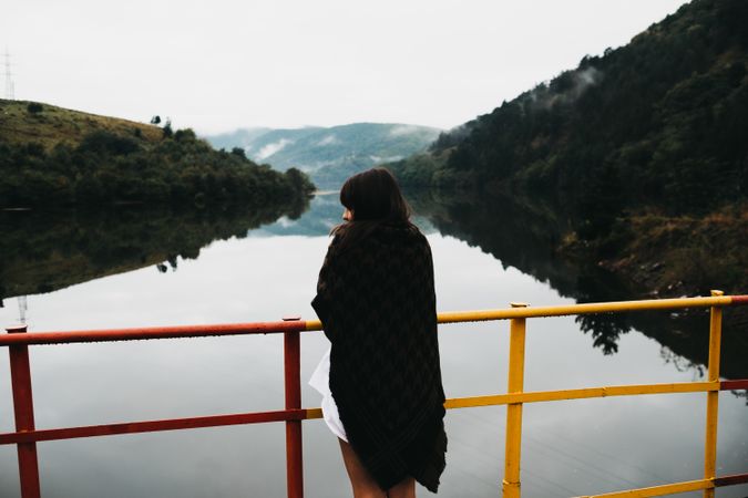Woman standing looking amazing lake near mountains