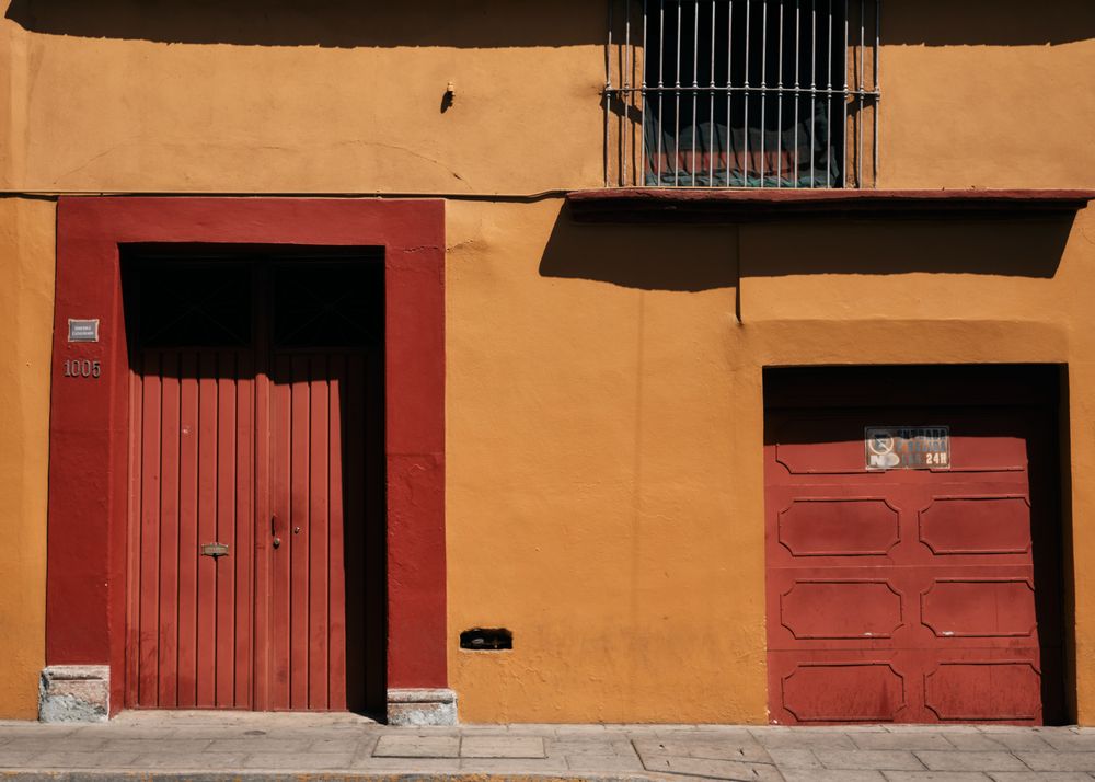 Terracota colored wall with dark doors and garage