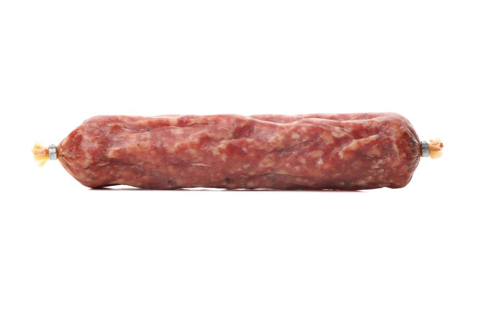 Encased cured meat lying on plain background